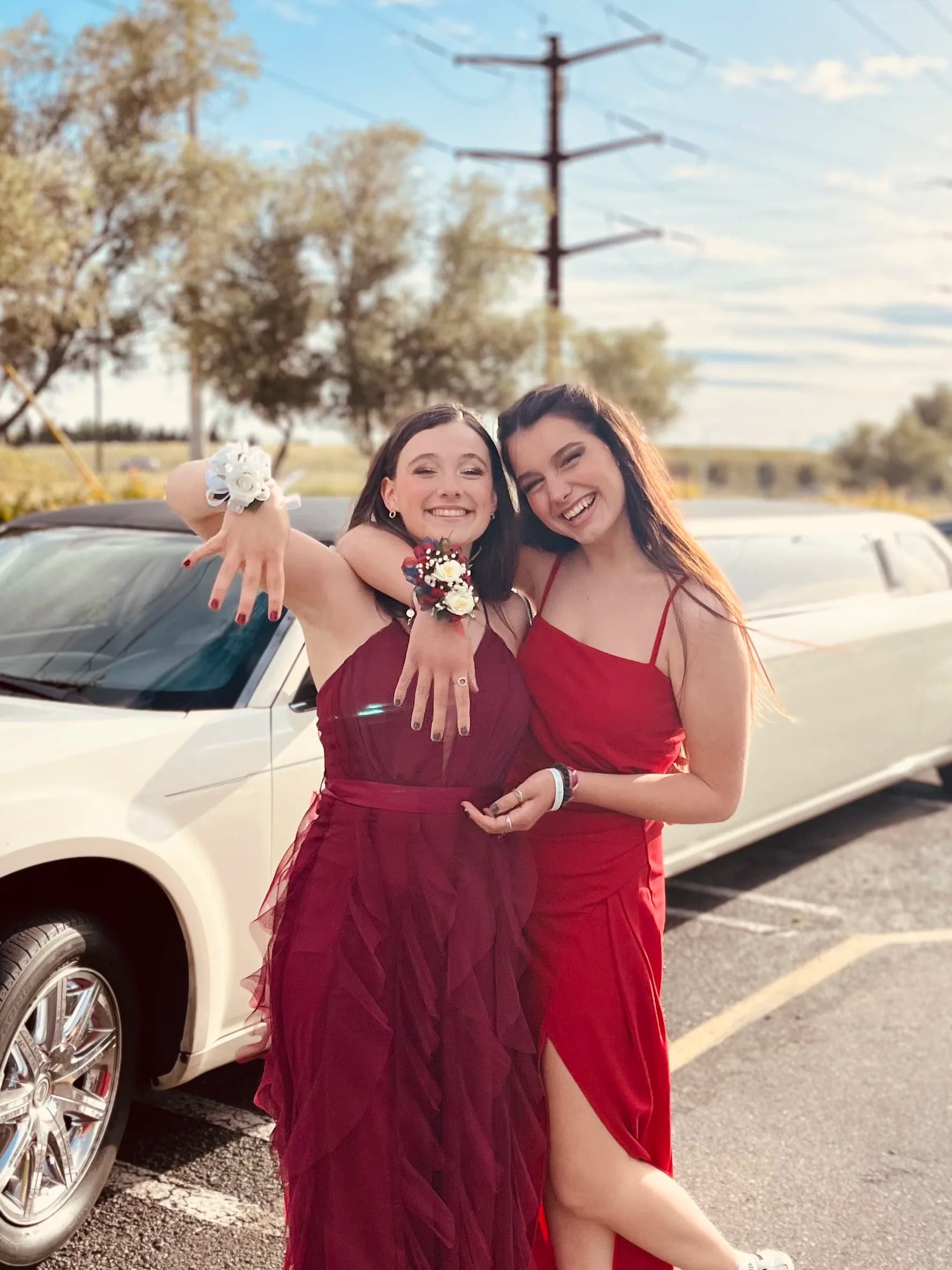 Due studentesse sorridenti in abiti eleganti posano insieme prima del prom, uno dei momenti più iconici del sistema scolastico americano e della vita degli studenti negli Stati Uniti.