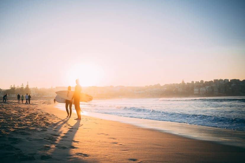 Studenti sulla spiaggia australiana al tramonto durante un anno all’estero in Australia, vivendo il territorio e il sistema scolastico australiano.