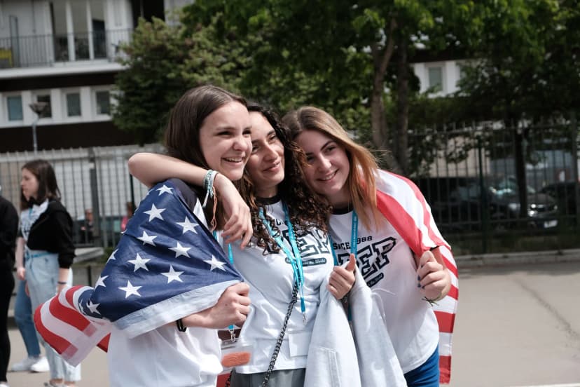 Studentesse abbracciate condividono un momento di amicizia durante un anno scolastico all’estero, tra scambio culturale, nuove relazioni e spirito internazionale.