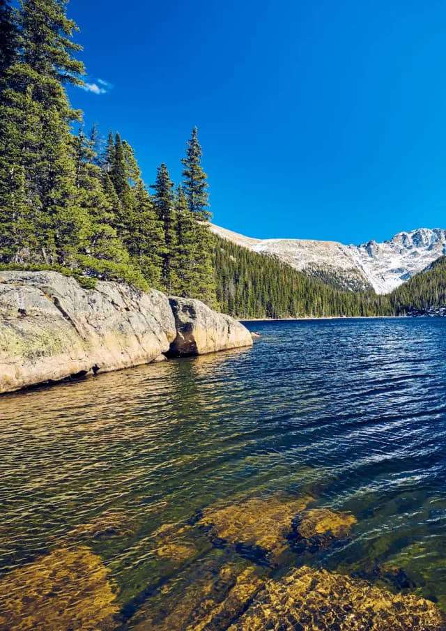 Lago circondato da foreste e cime delle Rocky Mountains, tra i paesaggi naturali degli Stati Uniti.